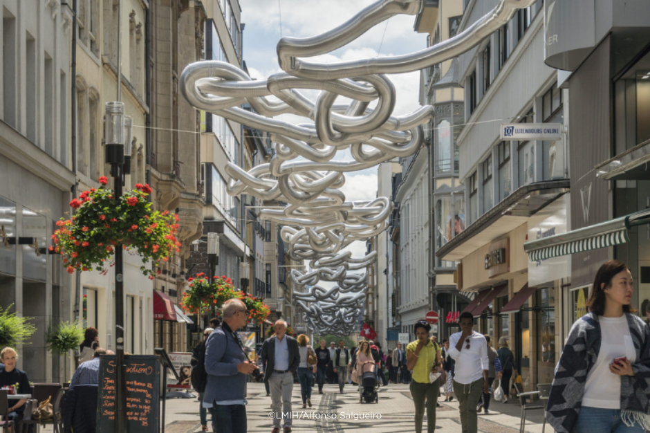 A busy shopping street in Luxembourg with pedestrians. 