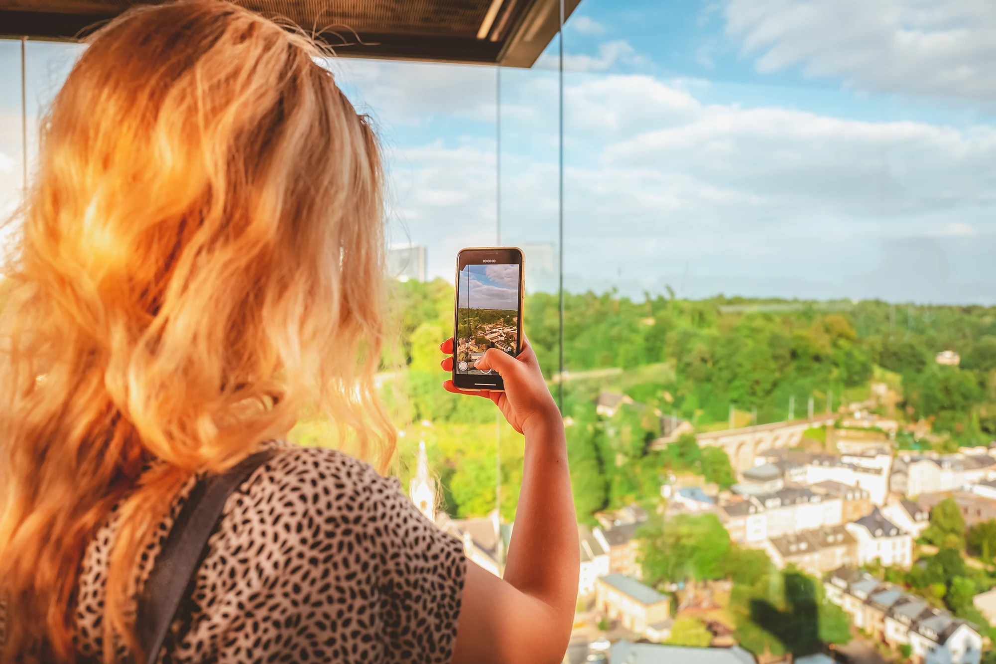 A girl in a panoramic lift taking a picture of Luxembourg City