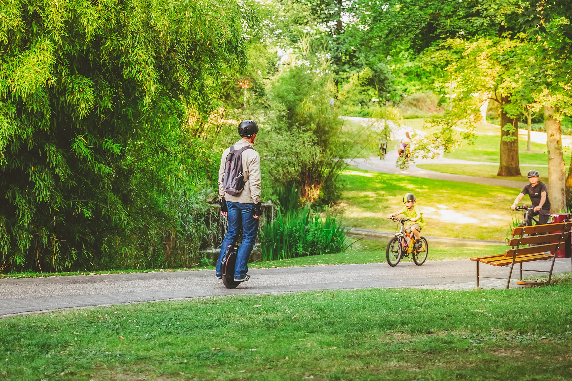 A man and a child cycling in a park in Luxembourg City